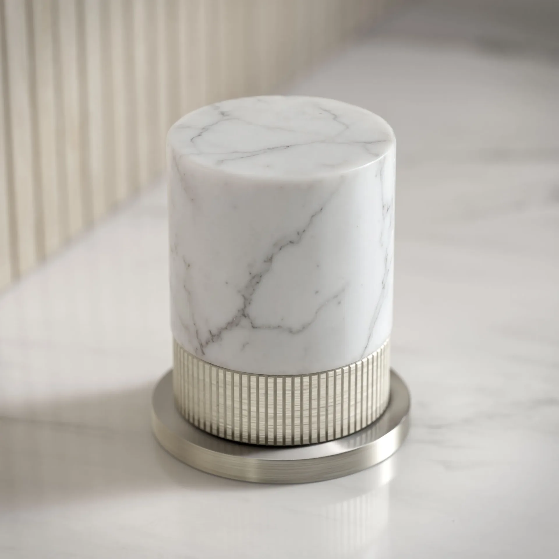 Photorealistic 3D rendering by 3D Corner of a marble cylindrical table lamp with ribbed metal base, high-end finish, marketing-ready rendering, ideal for furniture manufacturing catalogs.